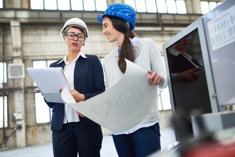 Positive female engineers discussing plan